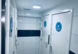 Interior of a clean and brightly lit bathroom corridor with multiple doors, each labeled with blue circular signs indicating 'Showers'.